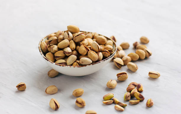 istock A white plate with rav pistachios in a shelll on a grey background 1357527576
