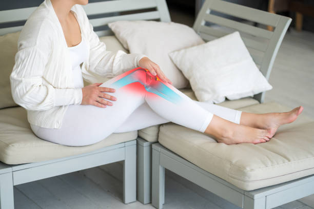 Knee pain, woman suffering from osteoarthritis at home stock photo