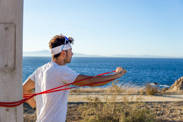 istock Young caucasian man exercising with a rubber band in the park 1357527976