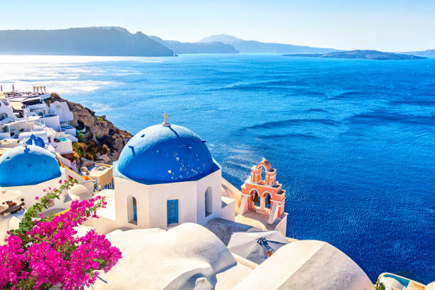 famosa vista icónica de santorini. cúpulas azules y casas blancas tradicionales con flores de buganvillas. pueblo de oia, isla de santorini, grecia. - santorini greece church travel fotografías e imágenes de stock