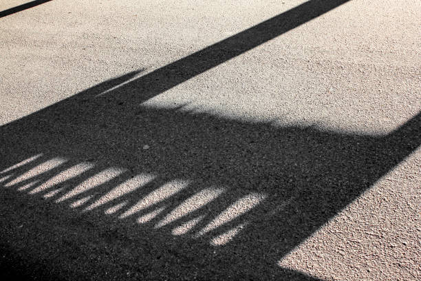 istock Hard black creative shadow on an asphalt road 1357528142