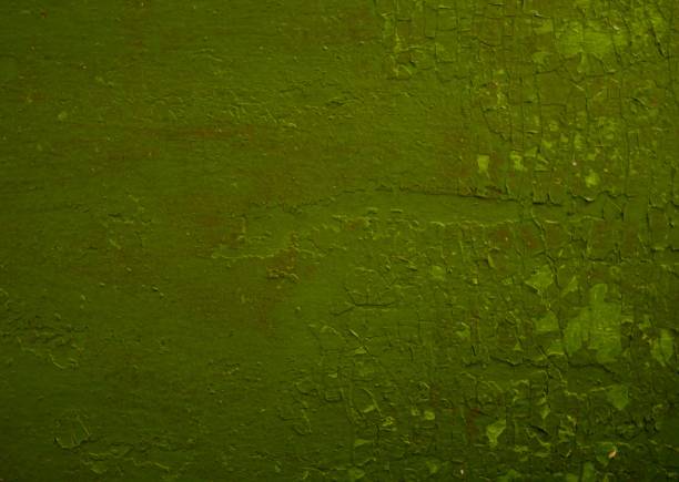 istock Old wall with peeling green paint with cracks 1357528928