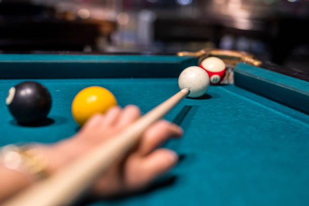 istock female hand preparing aiming the cue ball on a green billiard table 1357529006