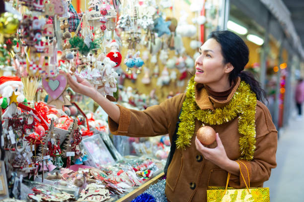 istock Woman choosing christmas decorations at fair 1357530215
