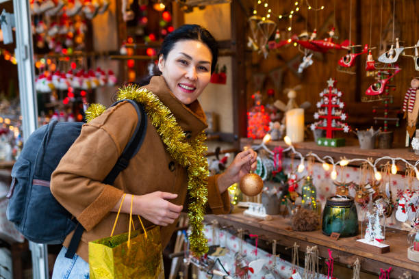 istock Woman choosing christmas decorations at fair 1357530303