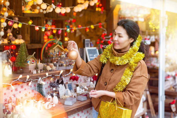 istock Asian woman at christmas fair 1357530304