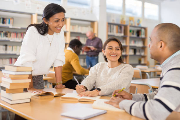 istock Latin American man with female friends studying in university library 1357530321