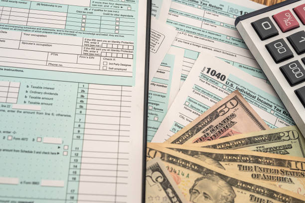 istock important tax forms 1040 dollar banknotes calculator scattered on the table 1357530471