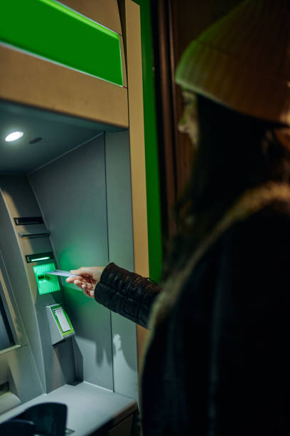 istock Young woman taking money from ATM 1357532195