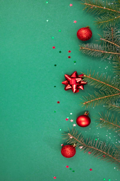 istock Christmas composition with holiday decorations and natural spruce branches on a green background. 1357532330