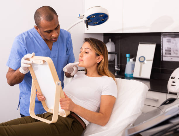 istock Beautician explaining woman hardware facial procedure 1357532401