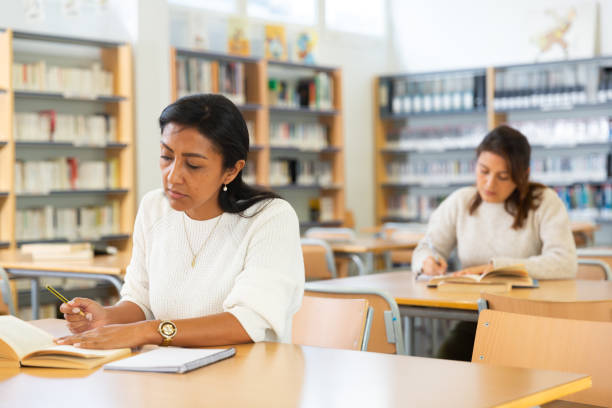 istock Focused adult Latina studying in university library 1357532480