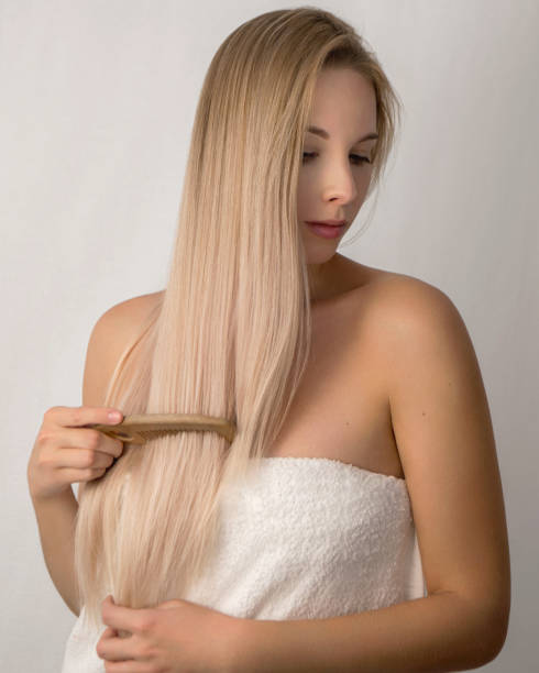 젊은 아름다운 여자 금발 브러쉬 그녀의 머리에 a 흰색 배경 에 a 흰색 수건 - long hair hair care straight hair towel 뉴스 사진 이미지
