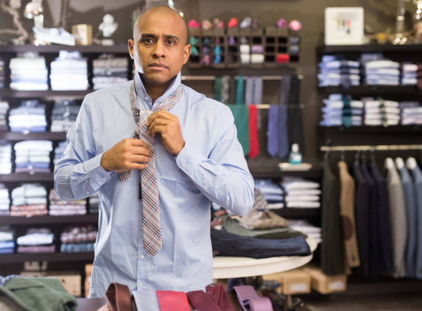 istock Man choosing new tie in clothing boutique 1357532609