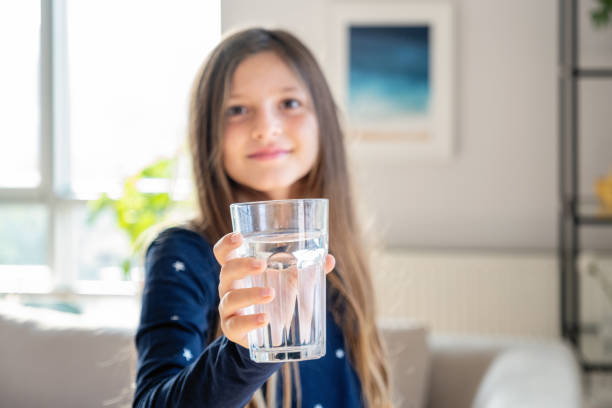 Long blond hair girl holding glass of water stock photo