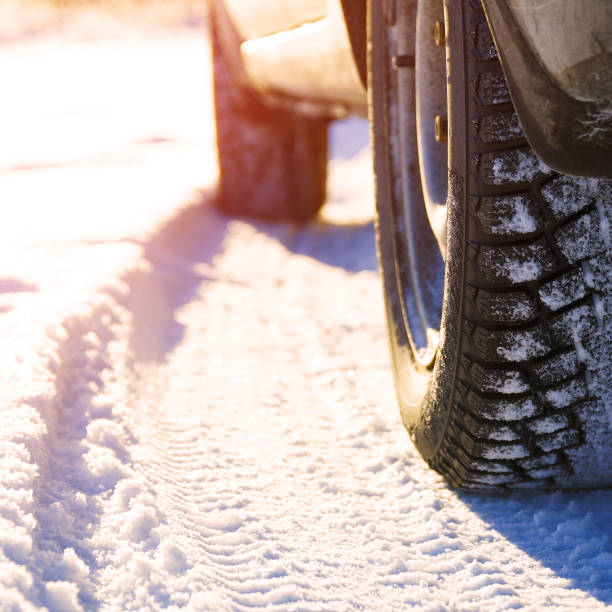 istock Studded winter car tires on snow-covered road 1357535505