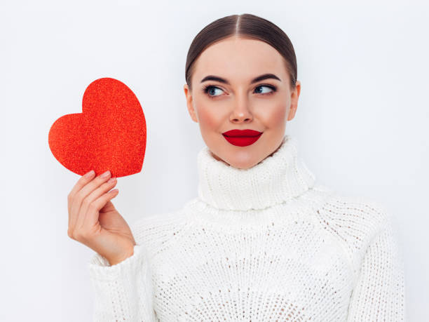 istock Beautiful young woman holding an artificial heart 1357536619