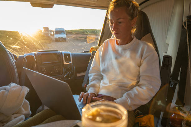 istock Side view of young female entrepreneur working from her van, digital nomad concept 1357538194