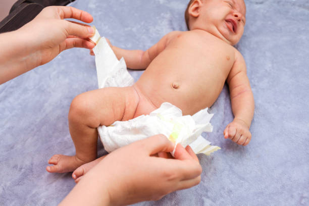 istock mom changes diapers to a crying baby, top view 1357538357