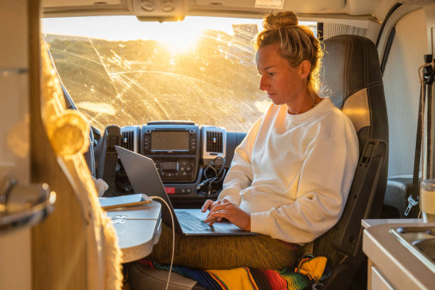 istock Side view of young female entrepreneur working from her van, digital nomad concept 1357538404