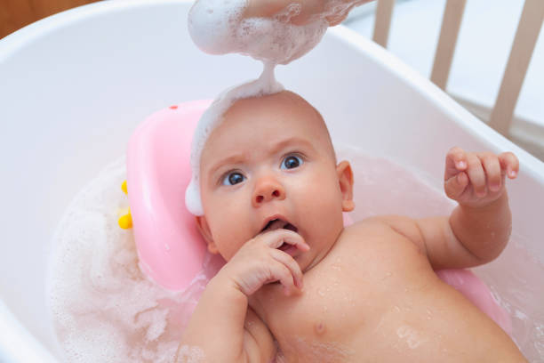 istock Baby bathes in the bathtub, foam on his head 1357538440