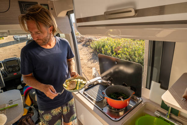istock Young man in his van cooking veggies, the van life experience 1357538474