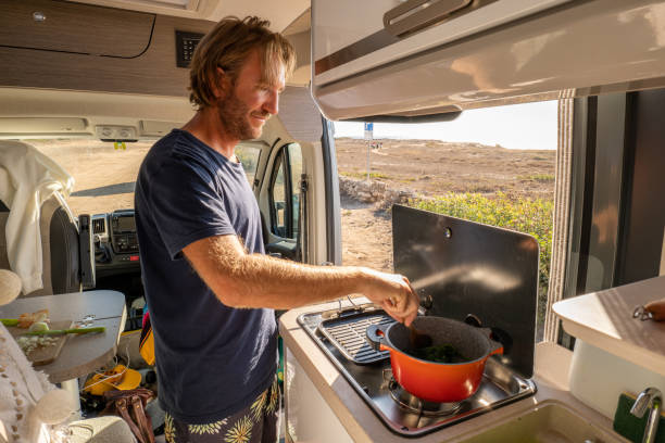 istock Young man in his van cooking veggies, the van life experience 1357538542