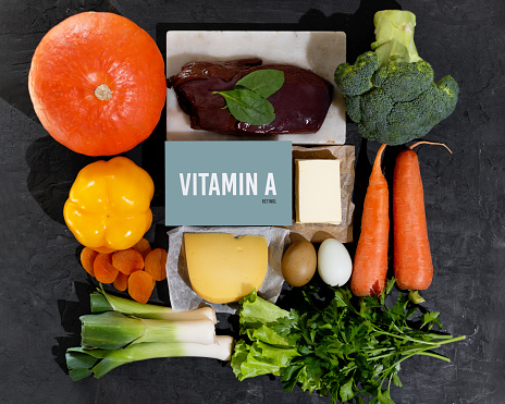 A set of natural products rich in vitamin A retinol. Healthy food concept. Cardboard sign with the inscription. Black background.