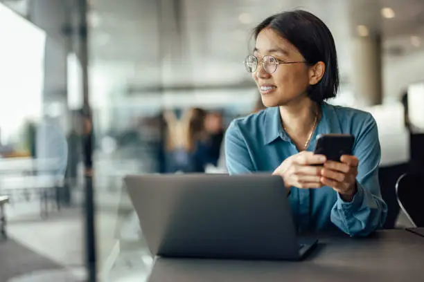 Photo of Joyful adult, asian woman, taking a glance through the window