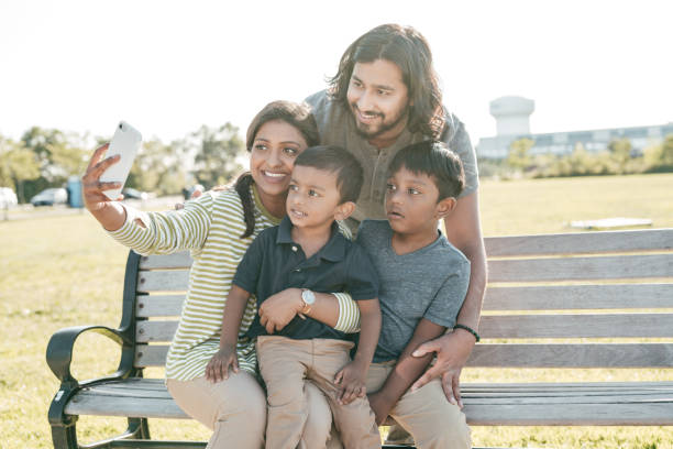 istock Two parents and two kids having fun outdoors in a sunny day 1357540280