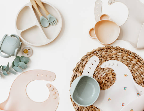 istock Flat lay Baby food accessories. silicone bib, fork and spoon on light background. 1357541924