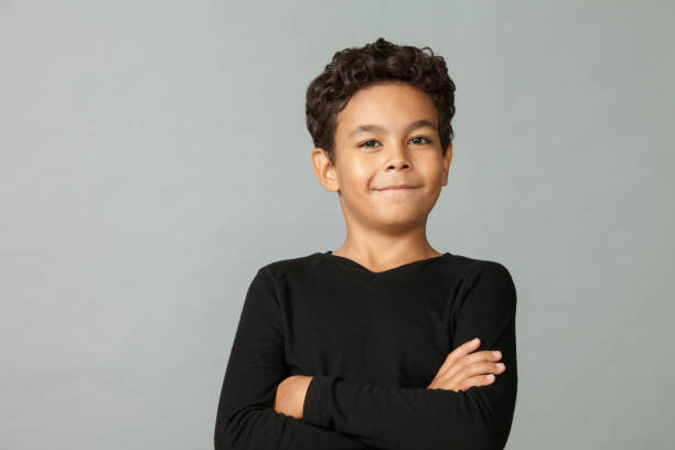 Close up studio portrait of 9 year old african american boy on gray background stock photo