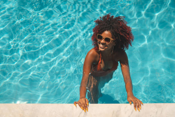istock Afro woman on vacation in the pool 1357543626