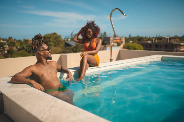 istock Afro couple on vacation at the rooftop pool 1357543632