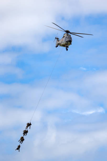 helicóptero utilitario militar aerospatiale as532 de la fuerza aérea suiza que transporta tropas por suspensión de cuerda. - as532 fotografías e imágenes de stock