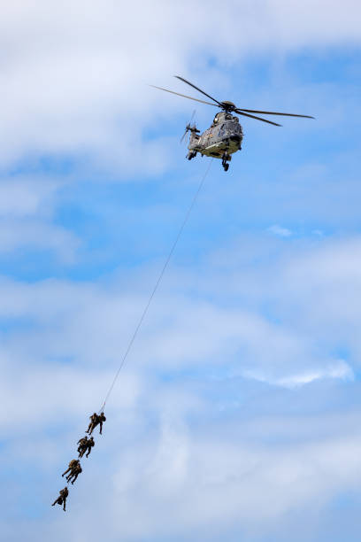 hélicoptère utilitaire militaire aerospatiale as532 des forces aériennes suisses transportant des troupes par suspension de corde. - as532 photos et images de collection