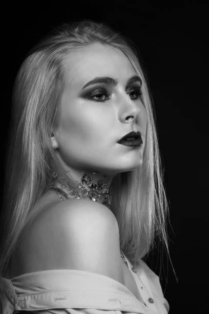 istock Monochrome beauty shoot: pretty blond model posing with foil on her neck 1357546938