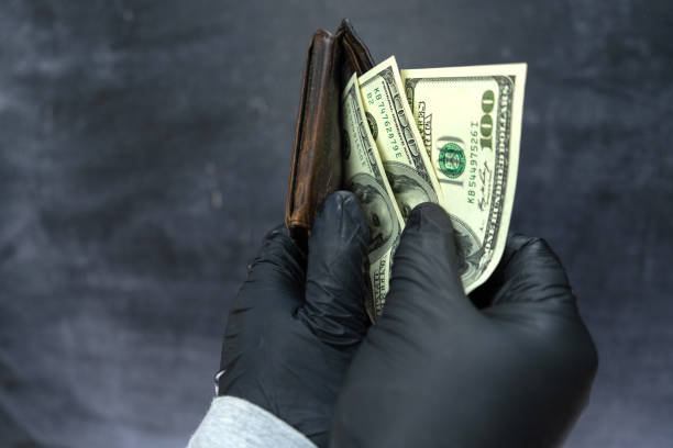 istock Black-gloved hands count the money in the stolen wallet. 1357547890