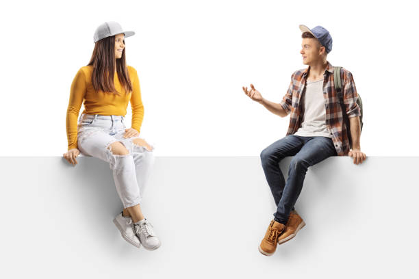 istock Young trendy male and female sitting on a panel and talking 1357548194