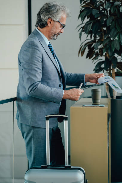 istock Smiling Mature Businessman Analyzing Insurance Documents at the Airport 1357548343