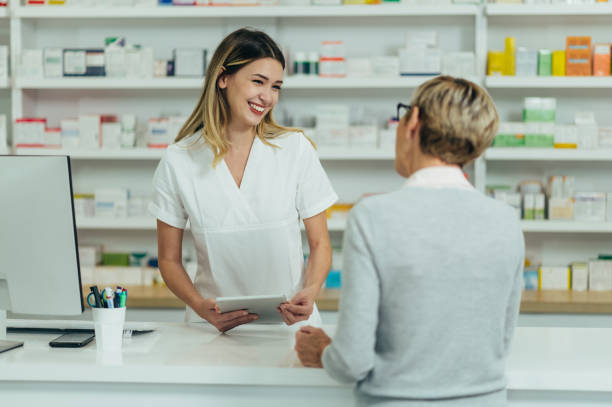 farmaceuta sprzedający leki w aptece starszej klientce - pharmacy pharmacist smiling pill zdjęcia i obrazy z banku zdjęć