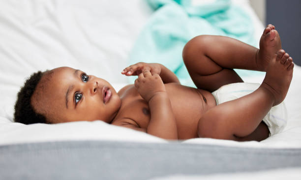 foto de un adorable bebé acostado en su pañal - baby cute selective focus close up fotografías e imágenes de stock