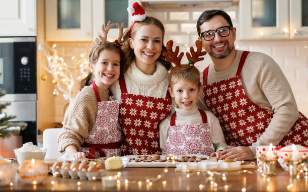 feliz família mãe, pai, dois filhos assando biscoitos de natal na cozinha - 18639 - fotografias e filmes do acervo