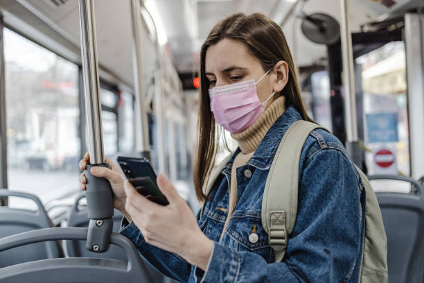 istock Woman with a protective face mask is using mobile phone in public transport 1357550192