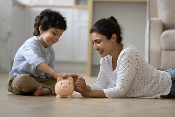 Happy Indian kid and young mom saving money together