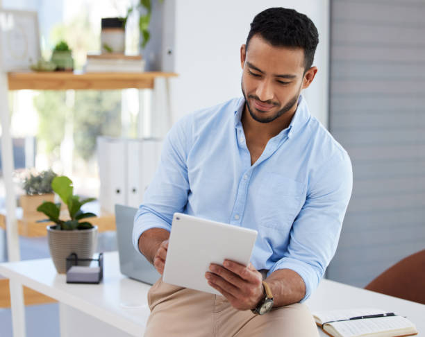 istock Shot of a young businessman using a digital tablet in an office 1357551730
