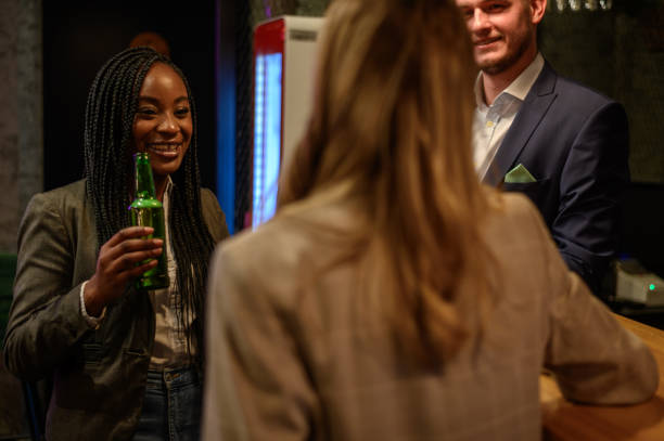 istock Woman drinking beer in the bar with her colleagues after work 1357551754