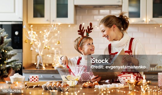 istock Young smiling woman mother making dough for christmas gingerbread cookies with cute little son 1357552934