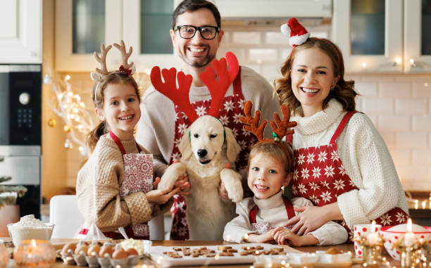 szczęśliwi rodzice rodzinni z dwójką dzieci i szczeniakiem golden retriever podczas robienia świątecznych ciasteczek w domu - 18641 zdjęcia i obrazy z banku zdjęć