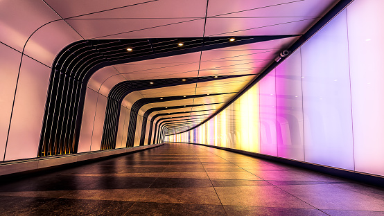 Bangkok, Thailand - Sep 30, 2022 : Perspective view of Ambient public underpass with white tiled walls and stripes of ceiling neon lights. Long pedestrian luminous tunnel, Space for text, Selective focus.